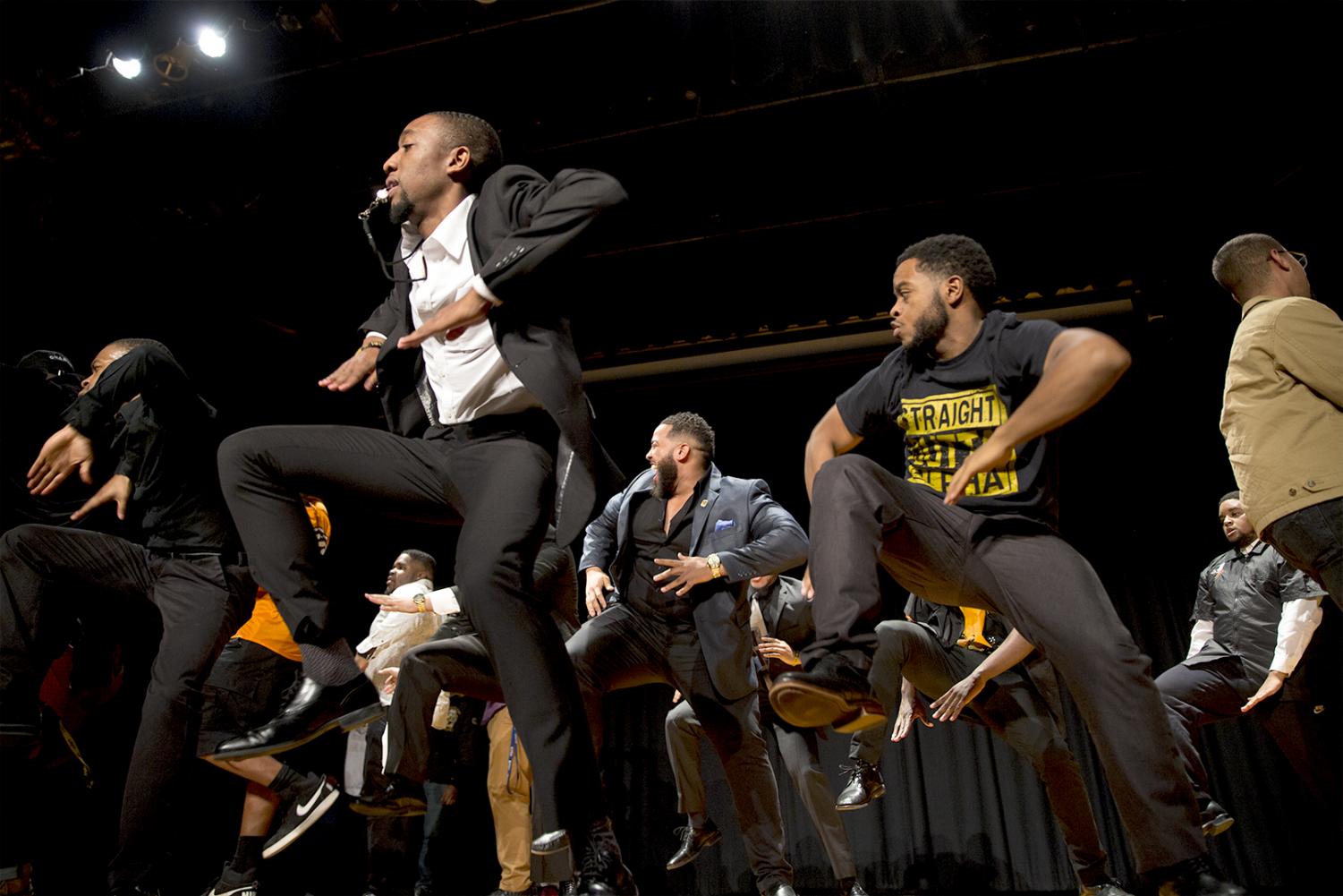 NPHC members throwing hand signs during a yard show