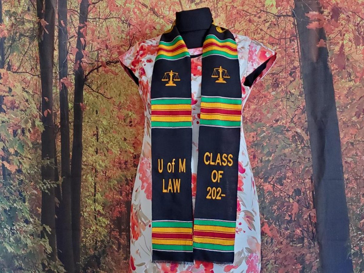 College graduate wearing a Kente cloth graduation stole over a gown