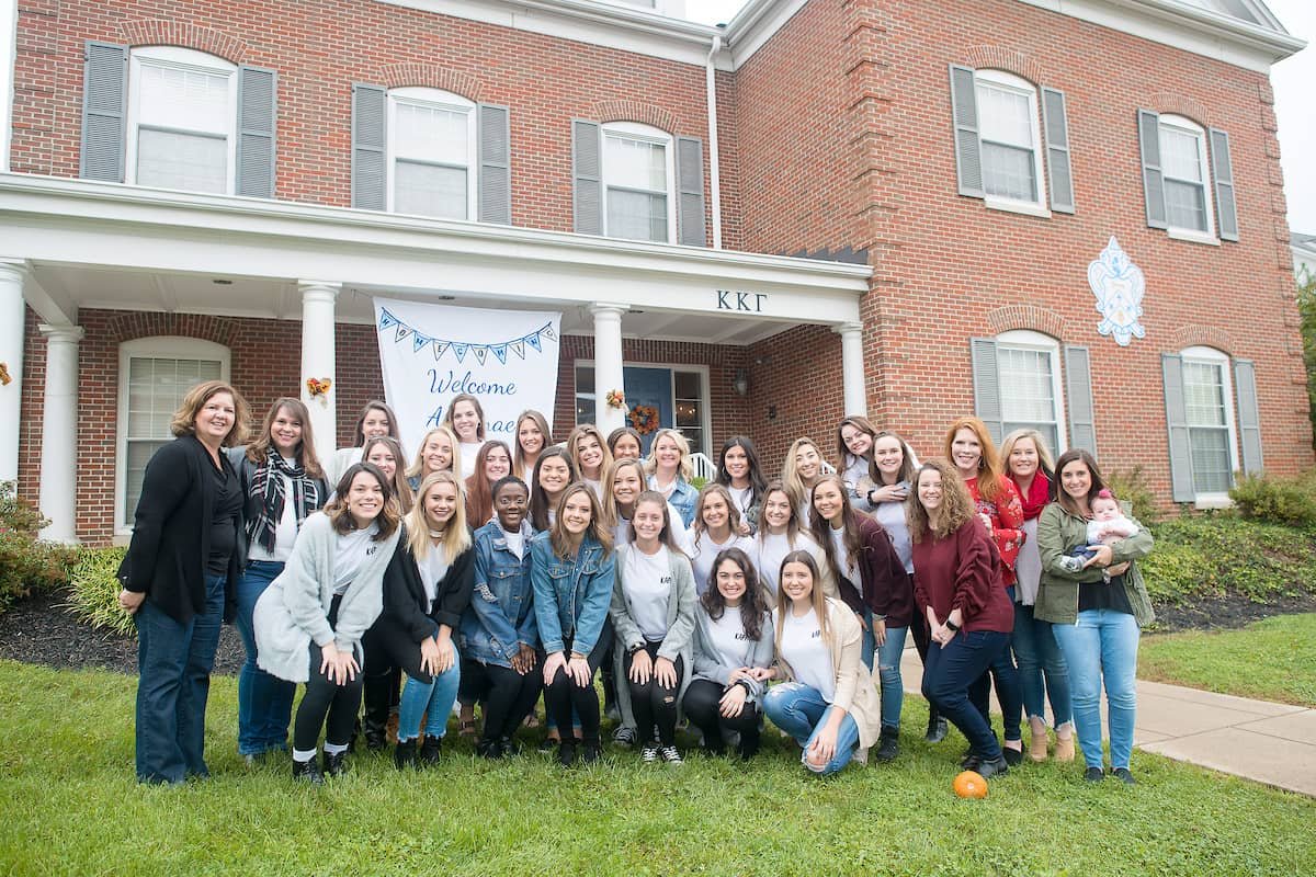 A sorority chapter and its alumnae gathered for a group photo outside the chapter house