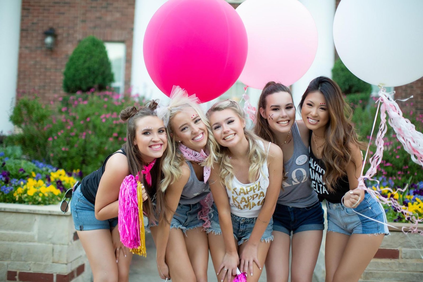 Sorority sisters posing together with oversized balloons at a chapter celebration
